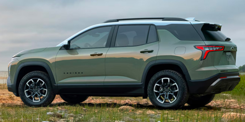 A green Chevy Equinox parked on a grassy field.